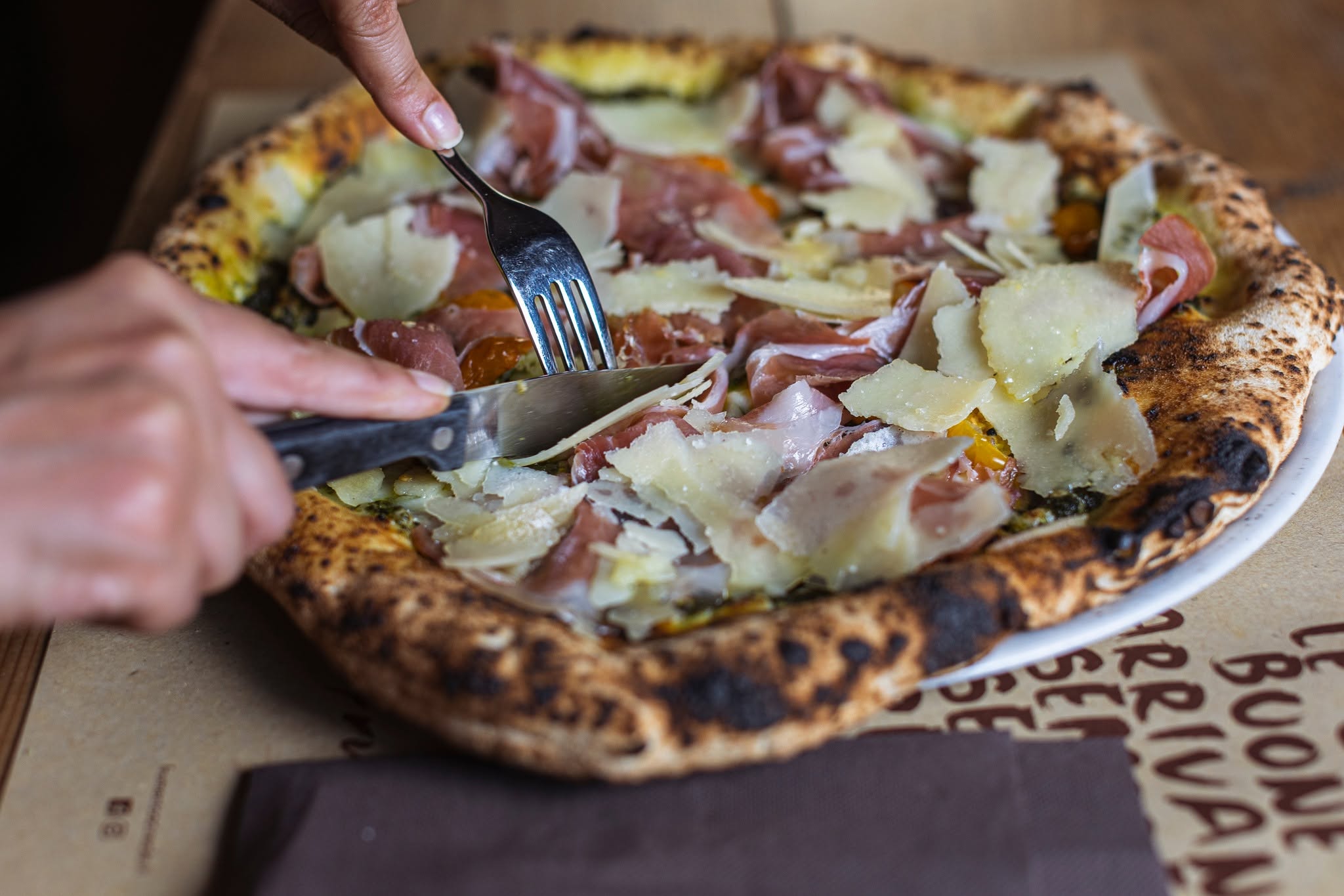 Pizza con crudo e scaglie di grana